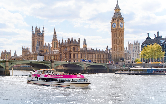 River cruise boat passing Big Ben and Houses of Parliament in London.