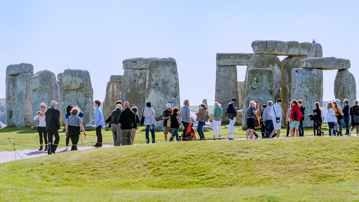 Visitors exploring Stonehenge in London, standing near ancient stone structures.