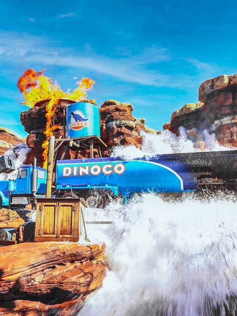 Disneyland Paris Cars attraction with Dinoco truck amidst water and fire effects.