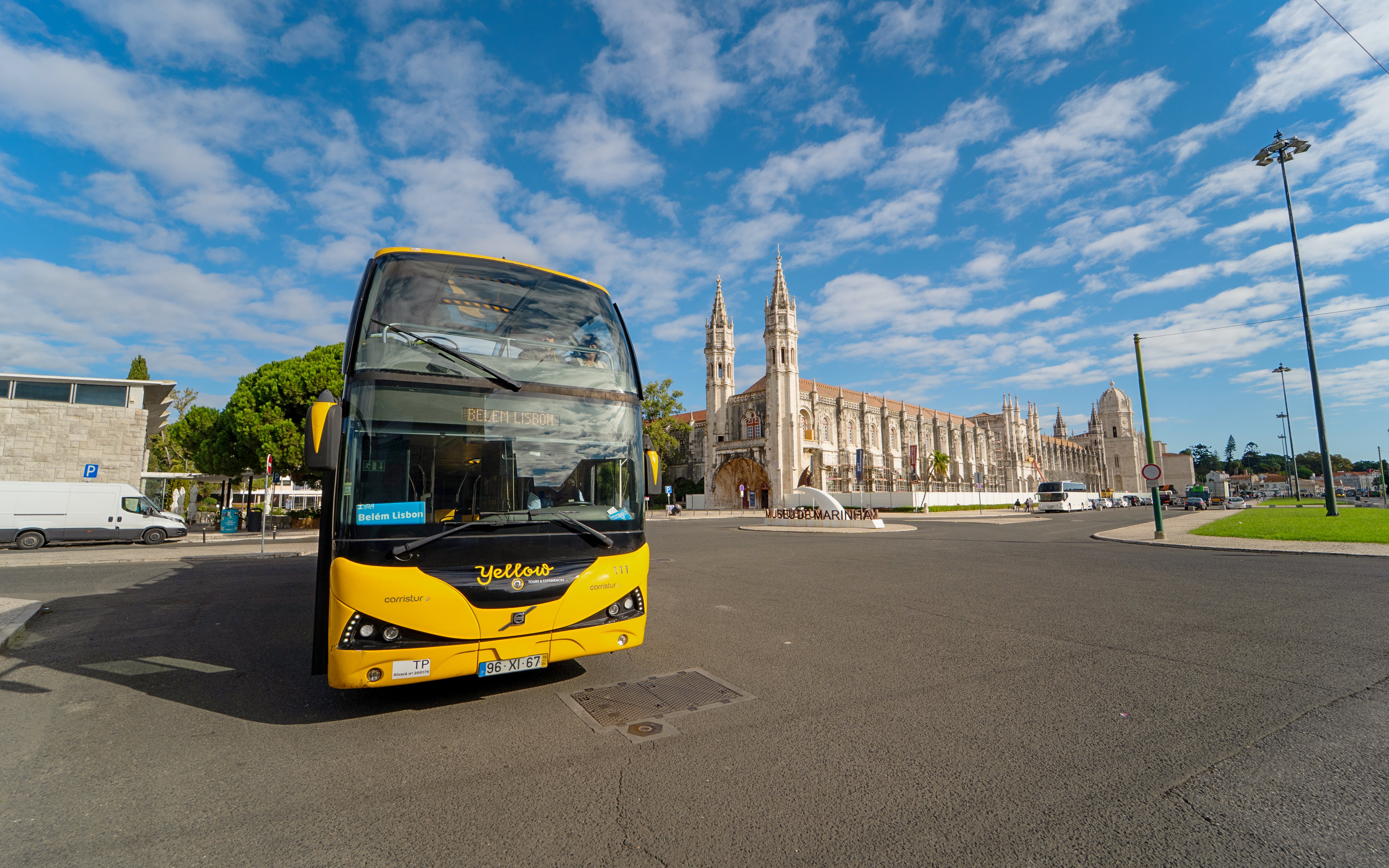 Yellow bus in front of Jerónimos Monastery during Lisbon Hop-on Hop-off tour.