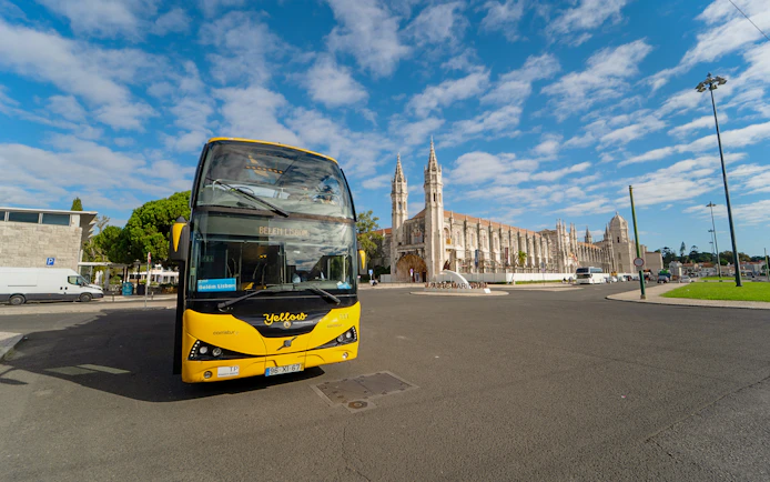 Yellow bus in front of Jerónimos Monastery during Lisbon Hop-on Hop-off tour.