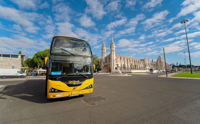 Yellow bus in front of Jerónimos Monastery during Lisbon Hop-on Hop-off tour.