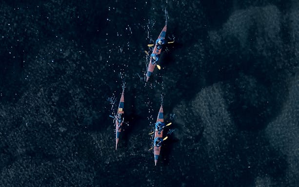 Kayakers paddling at night on a glowworm tour in Tauranga.