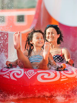 Child and adult enjoying a water slide ride at Aquaventure.