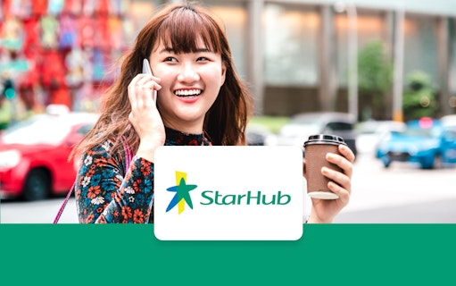 Person using phone with StarHub logo, holding coffee cup, city street background.