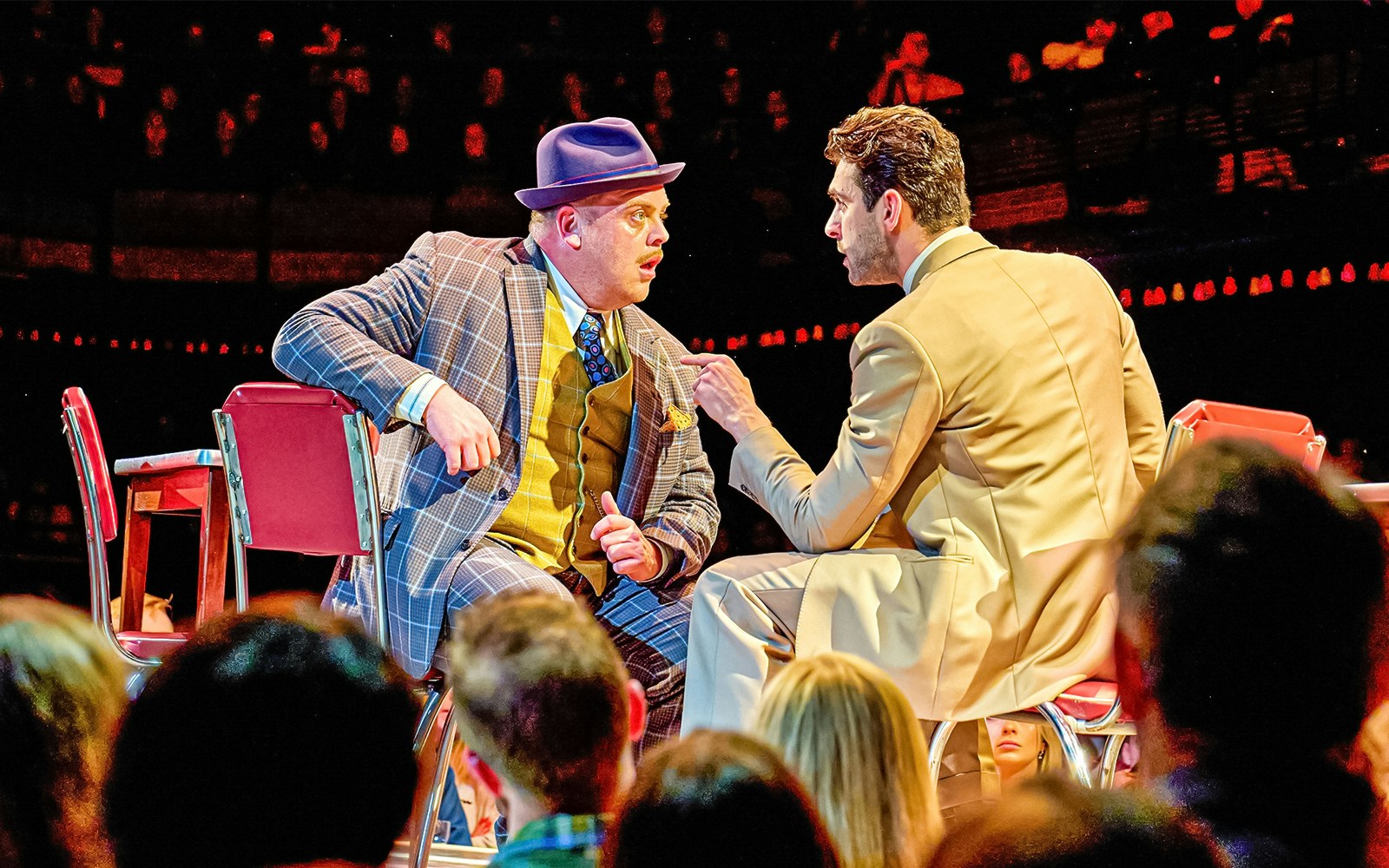 Two actors in a dramatic scene from the musical "Guys & Dolls" on stage.