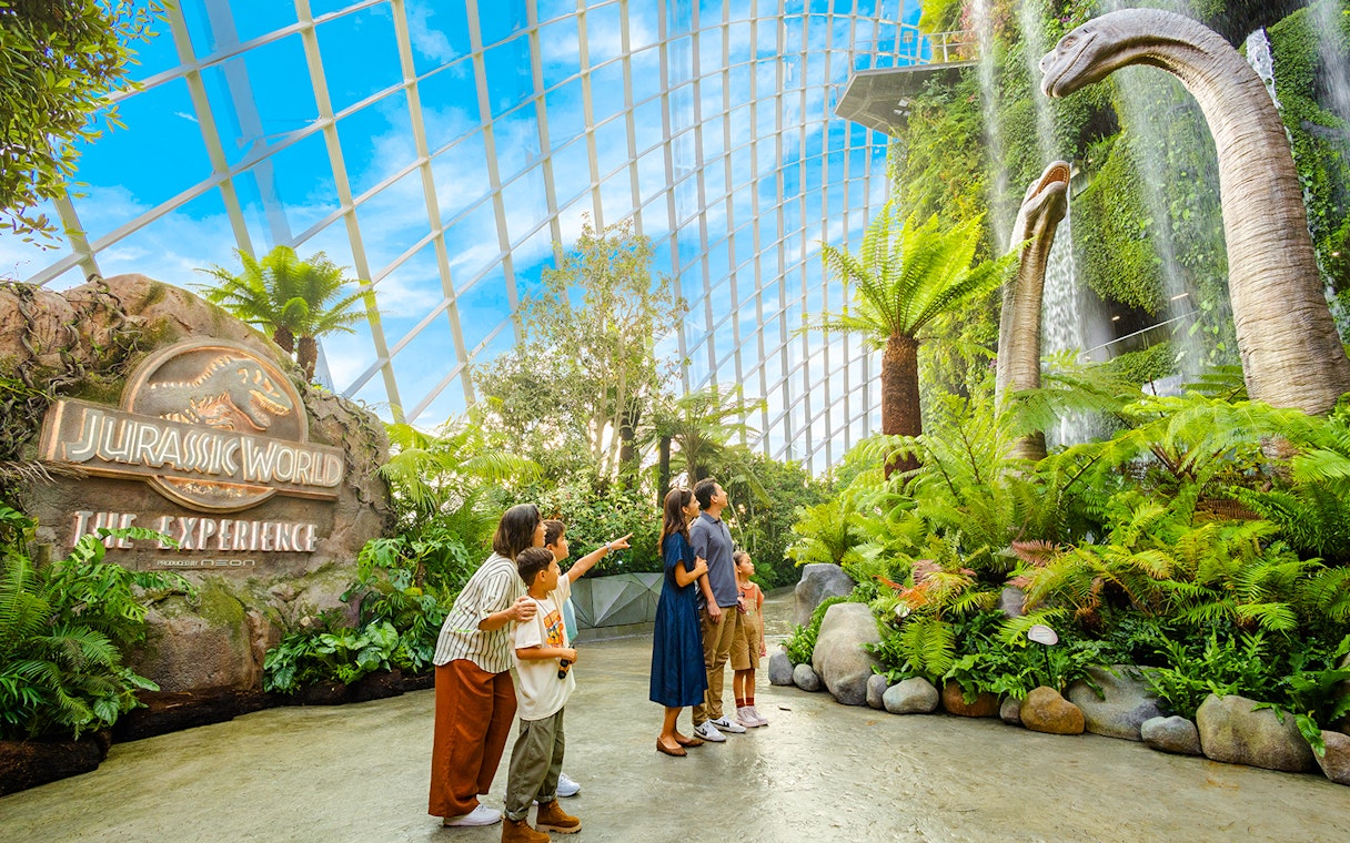 Visitors exploring dinosaur exhibits at Jurassic World, Cloud Forest, Gardens by the Bay, Singapore.