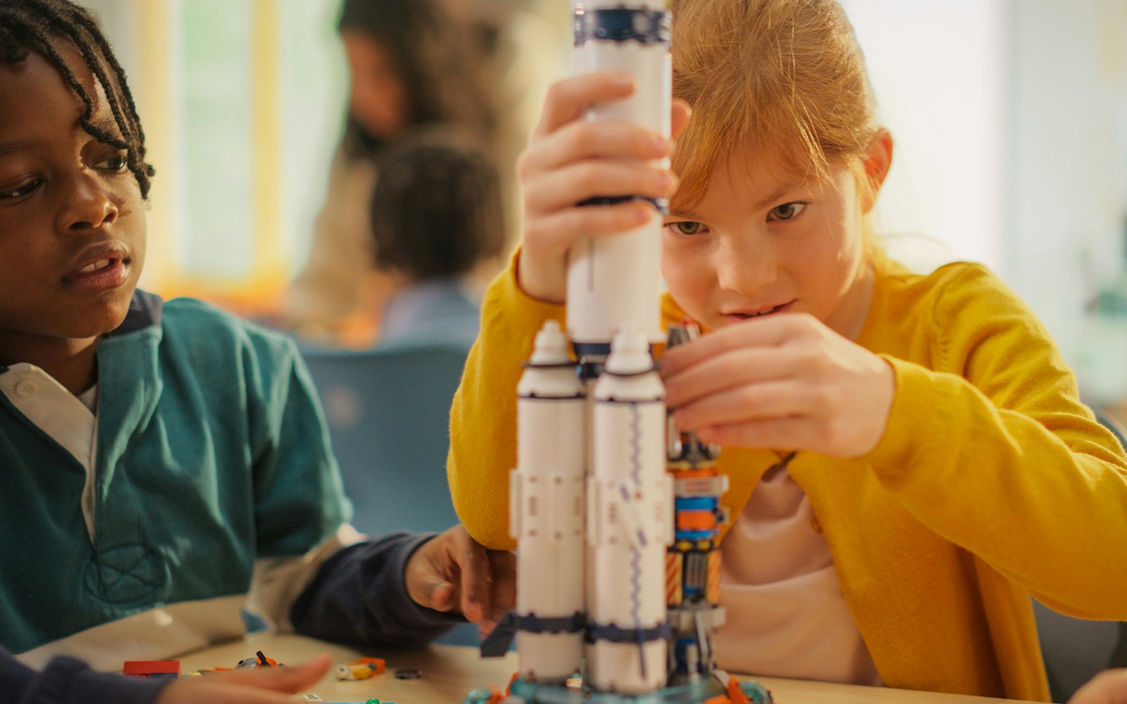 Children assembling a model spacecraft in a workshop.