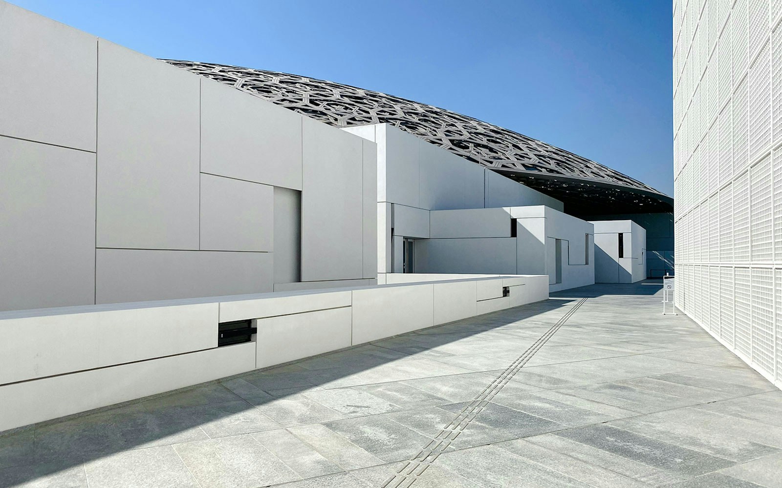 Louvre Abu Dhabi exterior with geometric architecture and dome roof.