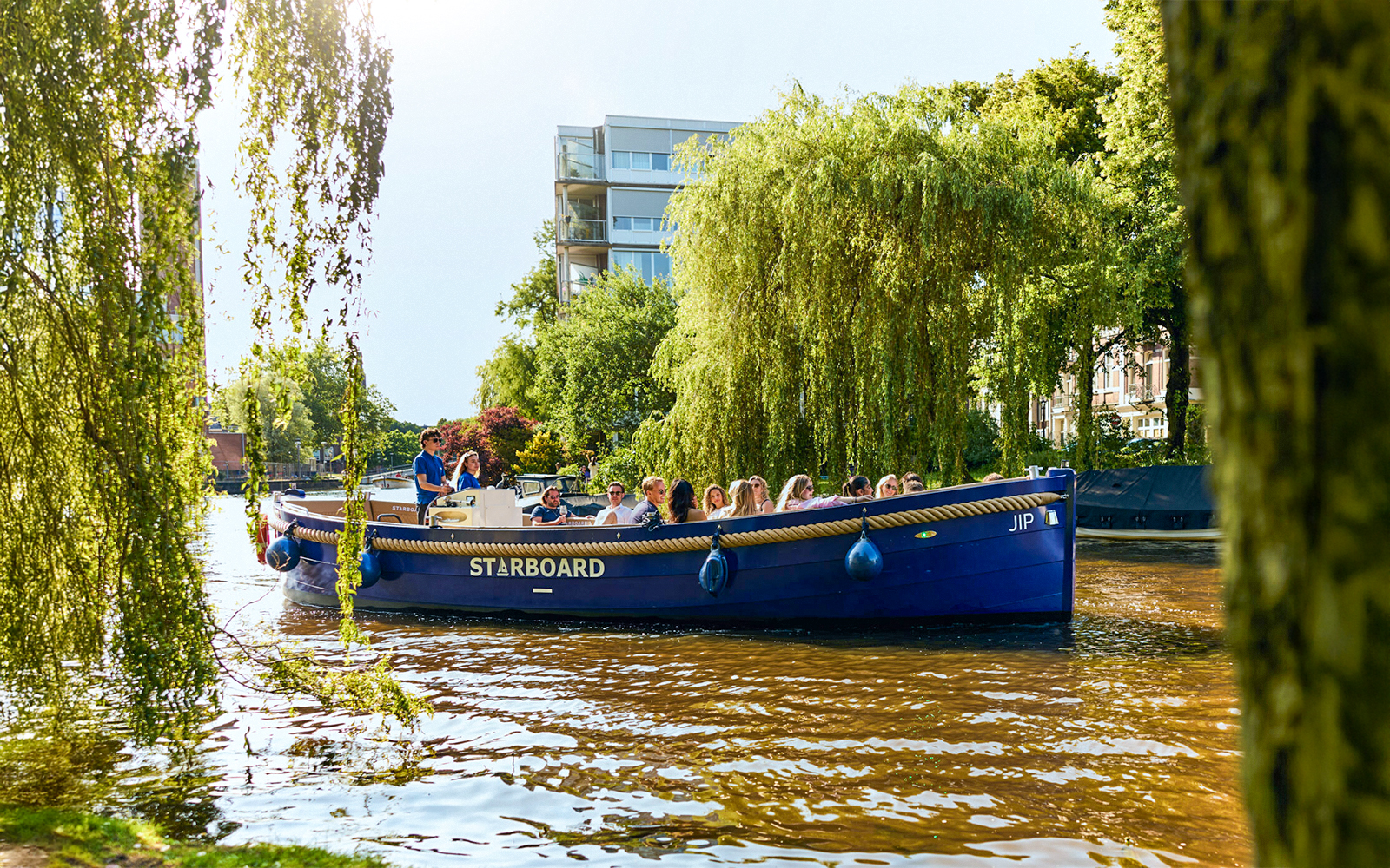 Canal boat with tourists on a Red Light District cruise in Amsterdam.