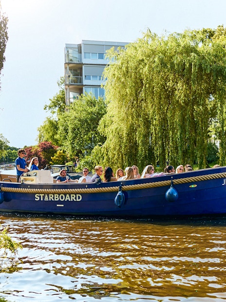Canal boat with tourists on a Red Light District cruise in Amsterdam.