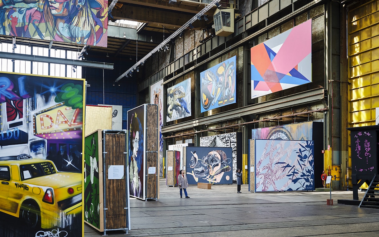 Straat Museum exhibits featuring vibrant street art and large murals in an industrial space.