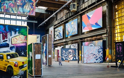 Straat Museum exhibits featuring vibrant street art and large murals in an industrial space.