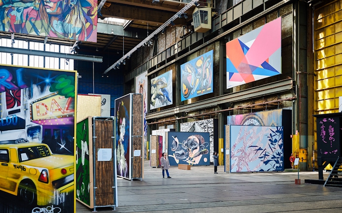 Straat Museum exhibits featuring vibrant street art and large murals in an industrial space.