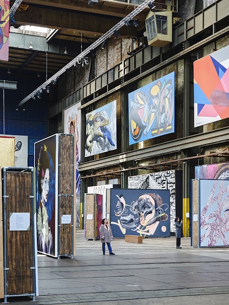 Straat Museum exhibits featuring vibrant street art and large murals in an industrial space.