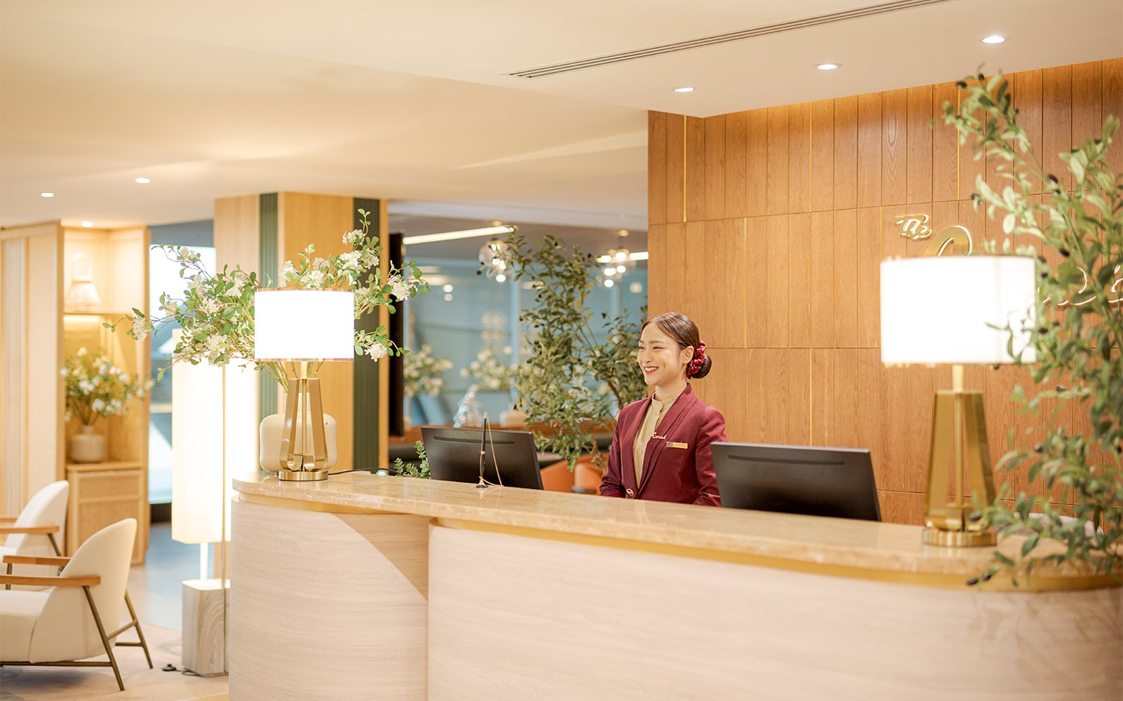 Reception desk at Coral Airport Lounges, Suvarnabhumi Airport, with staff member.