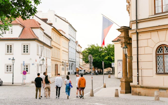 Guests walking near historic buildings around Prague Castle.