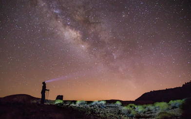 Stargazer with flashlight under Milky Way in Teide National Park, Tenerife.