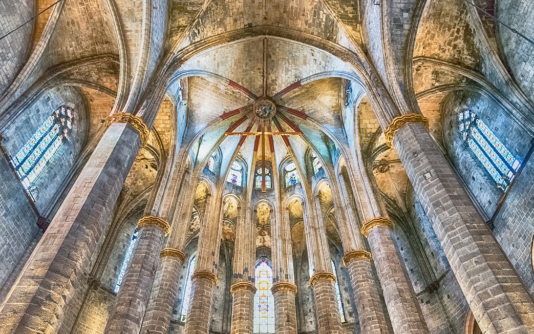 Interior view of Santa Maria del Mar's vaulted ceiling and stained glass windows.