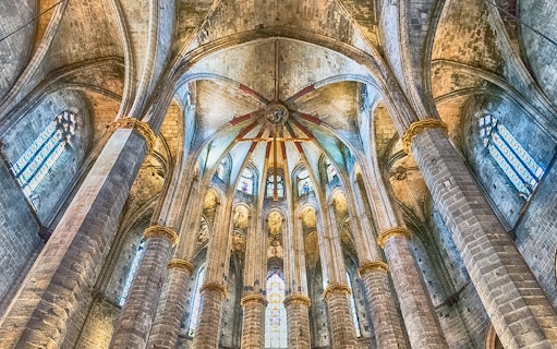 Interior view of Santa Maria del Mar's vaulted ceiling and stained glass windows.