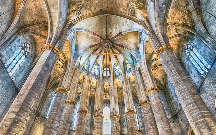 Interior view of Santa Maria del Mar's vaulted ceiling and stained glass windows.
