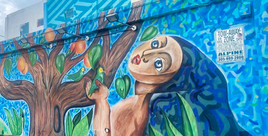 Mural of a figure with birds and a tree on Wynwood Walls, Miami, Florida.