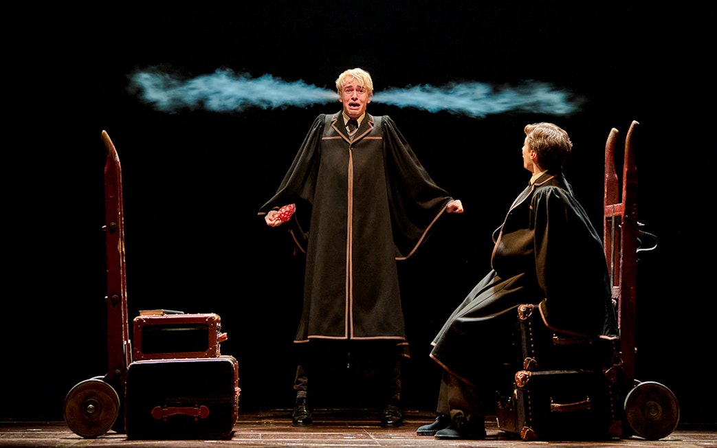 Two actors in wizard robes perform a scene from "Harry Potter and the Cursed Child" on stage.
