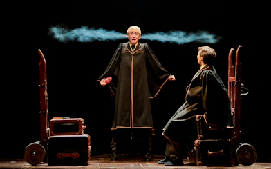 Two actors in wizard robes perform a scene from "Harry Potter and the Cursed Child" on stage.