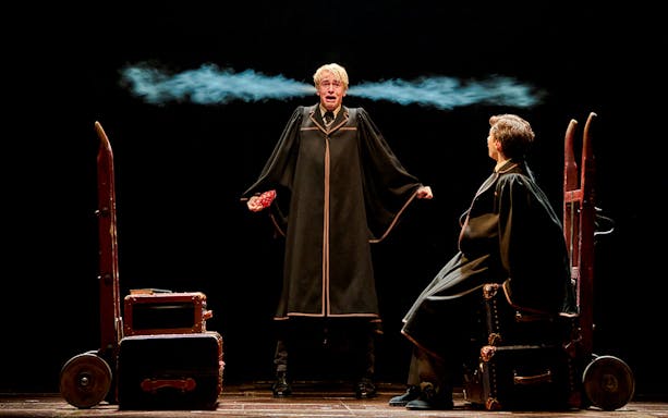 Two actors in wizard robes perform a scene from "Harry Potter and the Cursed Child" on stage.
