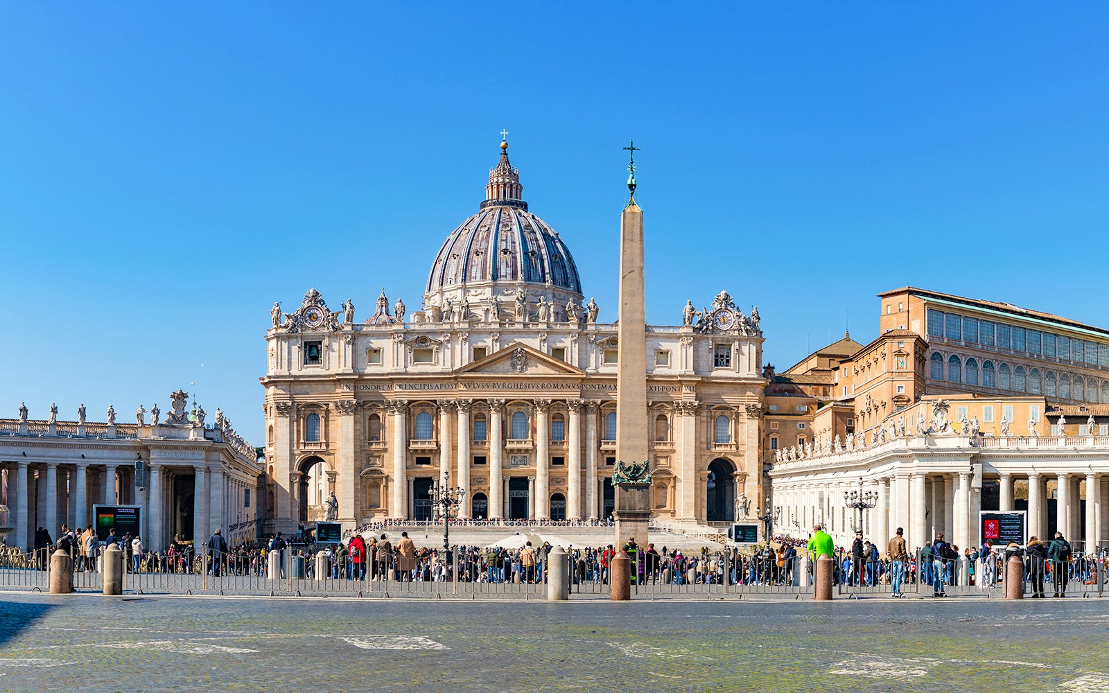 St. Peter's Basilica and Square with obelisk, Vatican City, crowded with visitors.