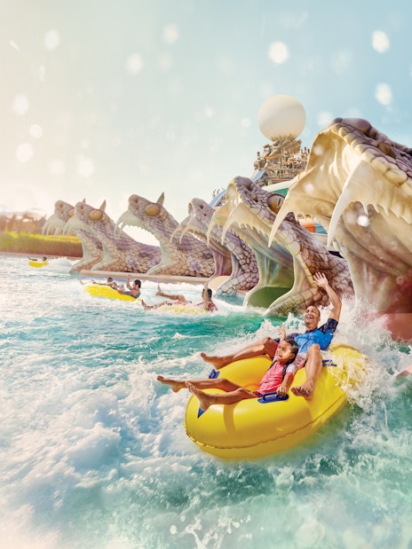 Visitors enjoying Slithers Slides at YAS Water Park, Abu Dhabi, on a yellow raft.