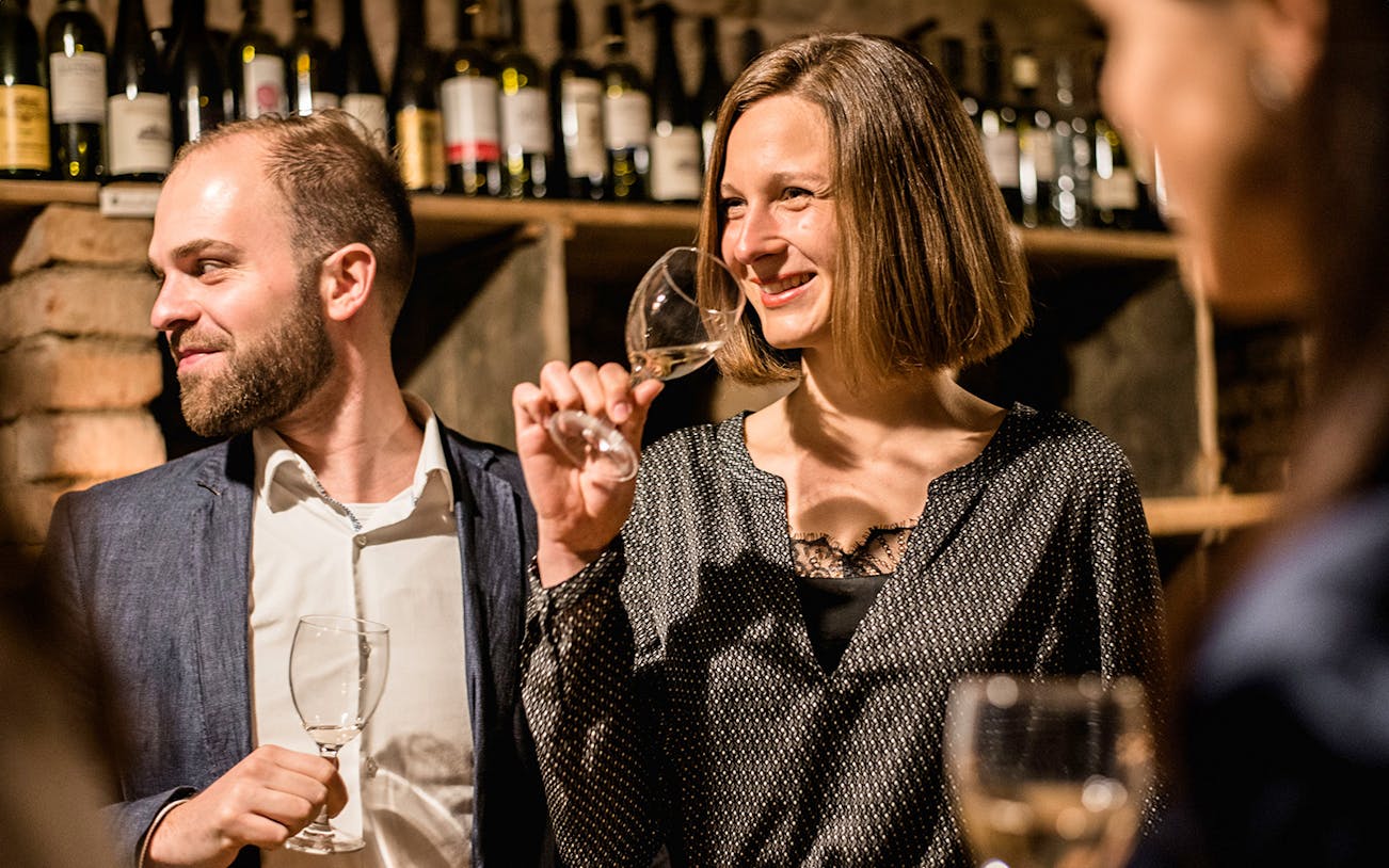 Guests enjoying a guided wine tasting in a private wine cellar.