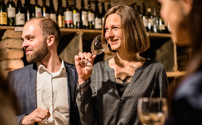 Guests enjoying a guided wine tasting in a private wine cellar.