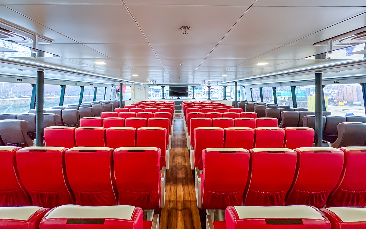 Interior of Singapore to Batam ferry with rows of red seats.