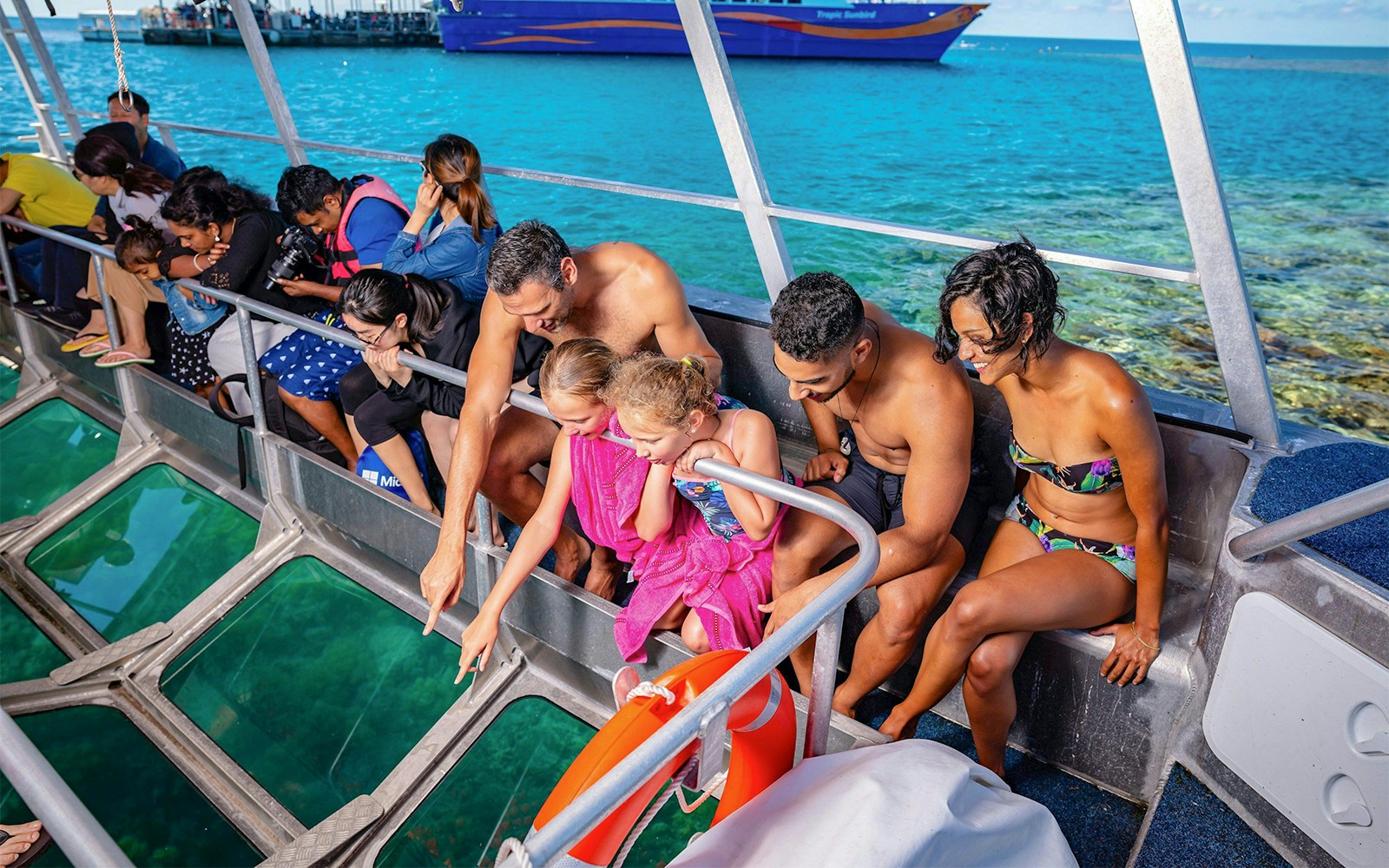 Tourists observing marine life through a glass bottom boat at Fitzroy Island, Great Barrier Reef.