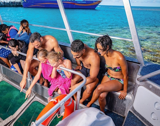 Tourists observing marine life through a glass bottom boat at Fitzroy Island, Great Barrier Reef.