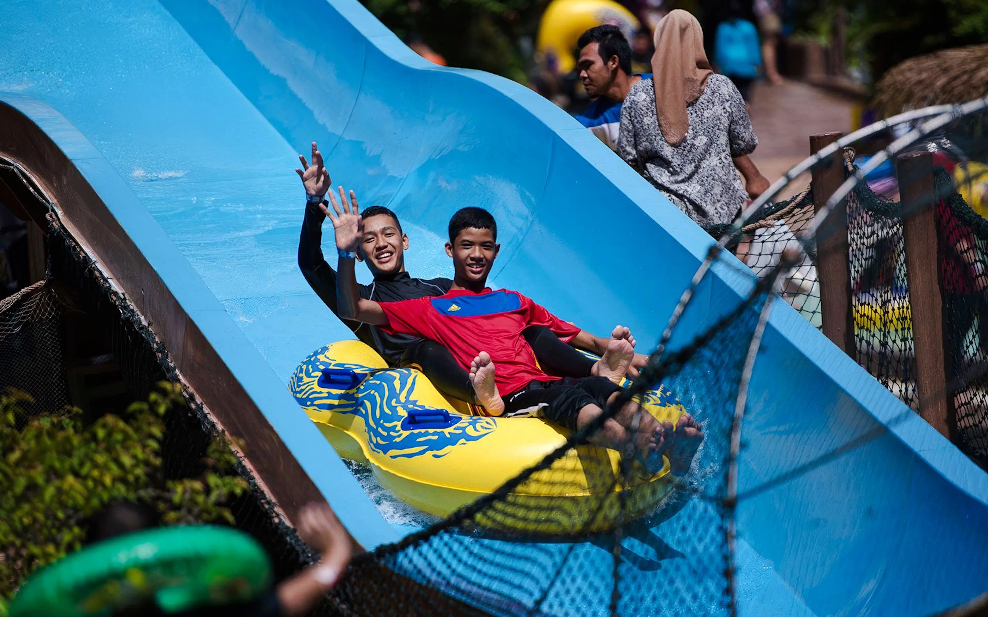 Friends enjoying a water slide at Wet World Water Park Shah Alam.