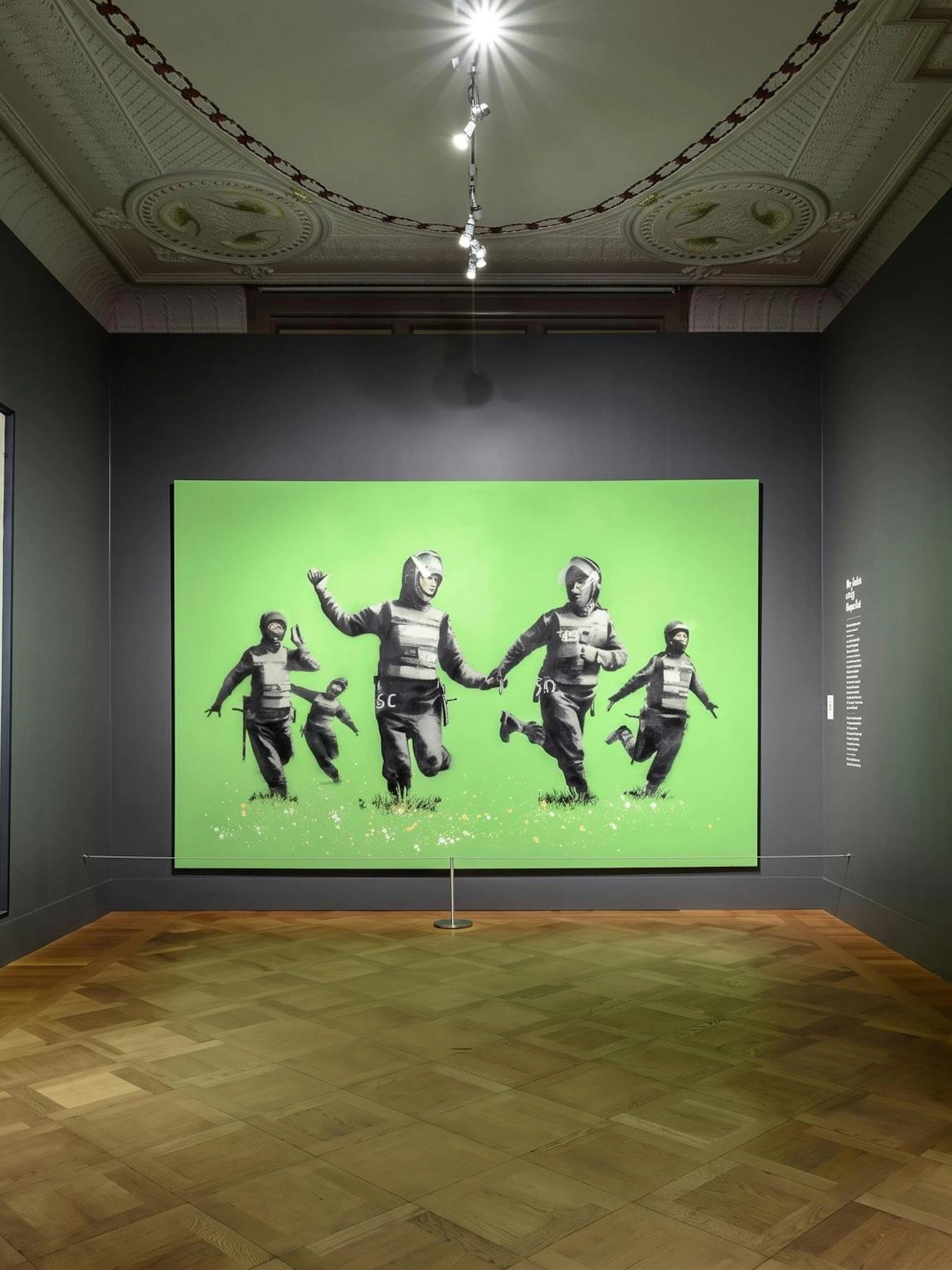 Exhibit of modern art with police-themed paintings at Moco Museum, Amsterdam.