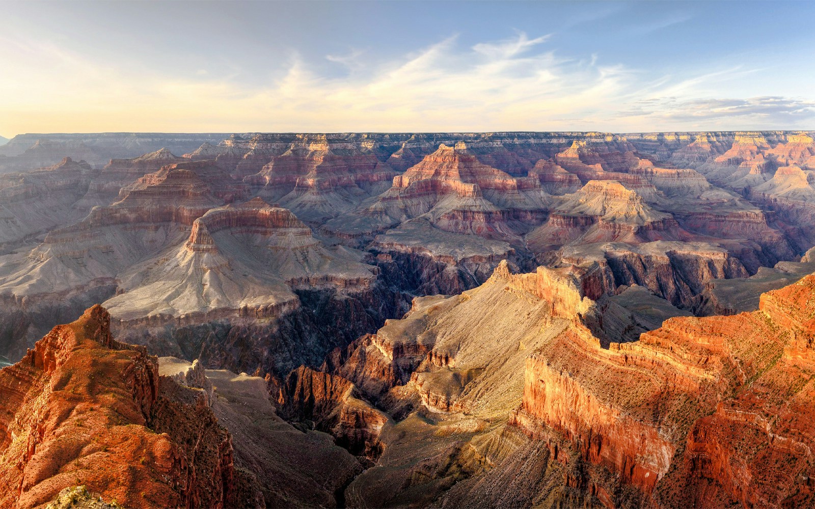 Grand Canyon panoramic view with layered rock formations under a clear sky.