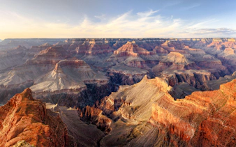 Grand Canyon panoramic view with layered rock formations under a clear sky.
