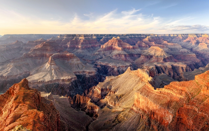 Grand Canyon panoramic view with layered rock formations under a clear sky.