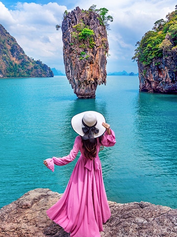 Woman in pink dress overlooking James Bond Island in Phang Nga Bay, Phuket.