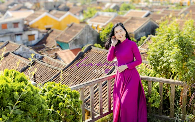 Woman in traditional dress overlooking Hoi An rooftops, Da Nang tour.