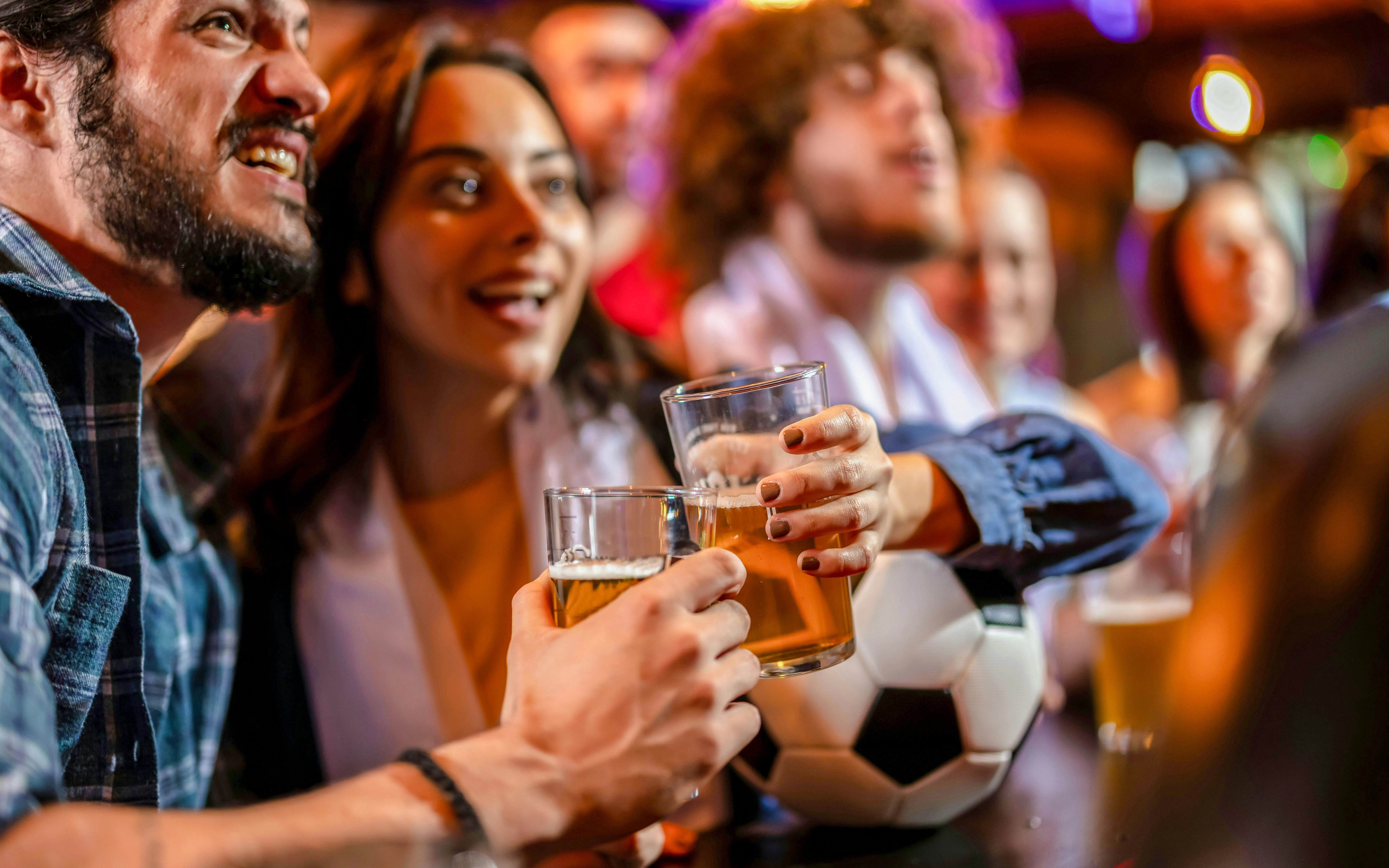 People enjoying drinks and watching a game at a bar in the Latin Quarter.
