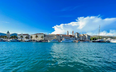 Boats docked along Trogir waterfront with historic buildings in the background.