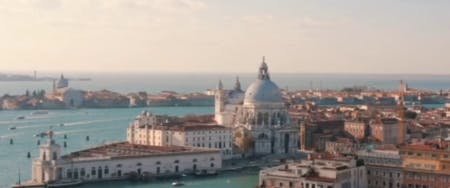 Gondola gliding through Venice canals with historic buildings in the background.