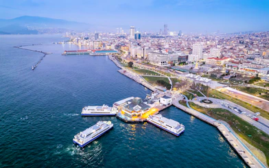 Aerial view of Izmir coastline with ferries docked at a pier during daytime.