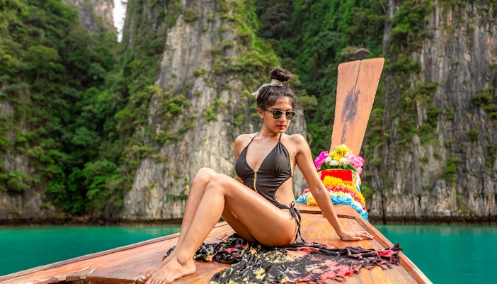 Woman in bikini on longtail boat approaching Maya Bay, Phi Phi Islands tour.