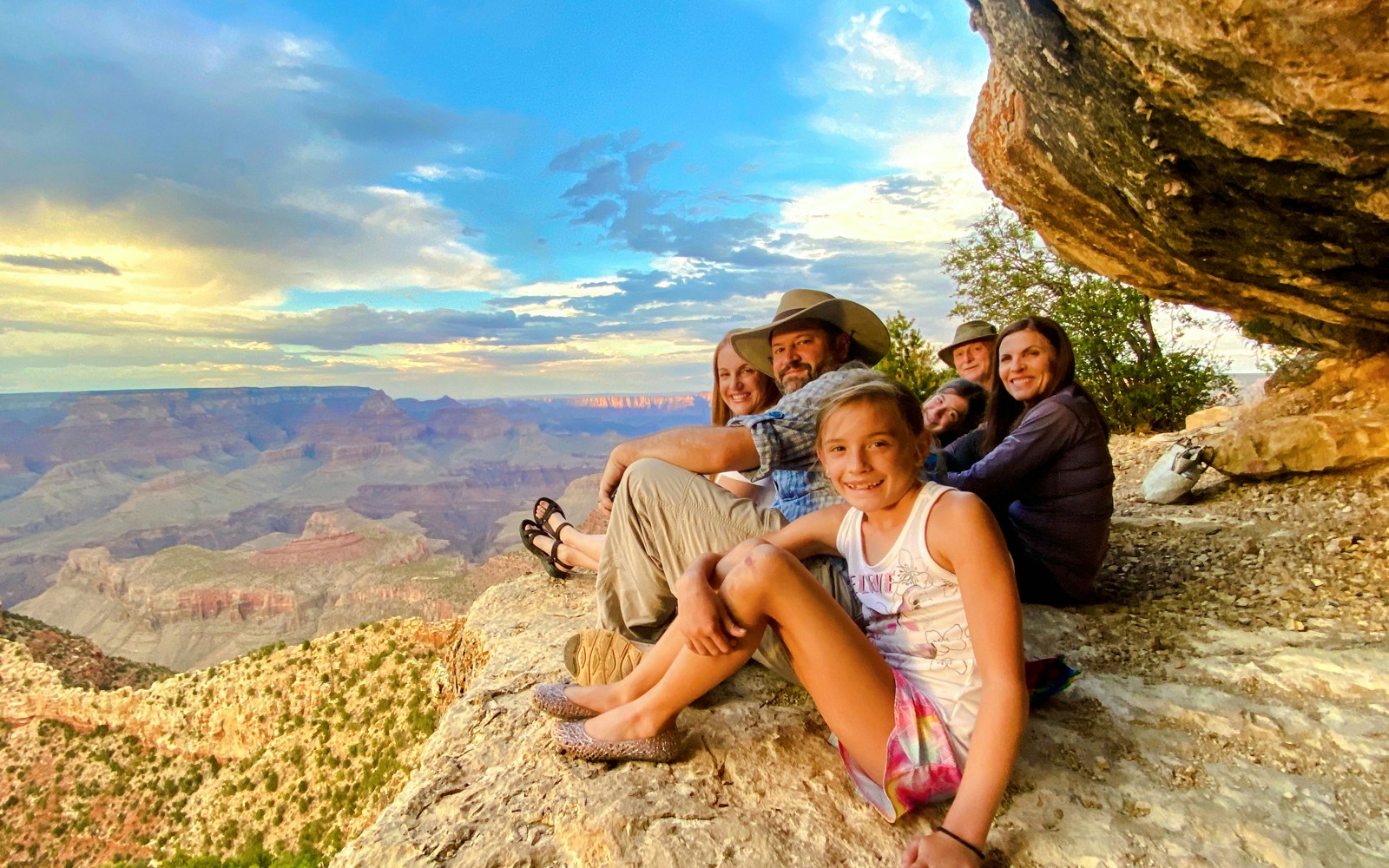 Guests seated on a cliff edge, viewing the Grand Canyon South Rim during a 45-minute airplane tour.