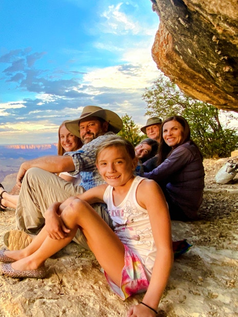 Guests seated on a cliff edge, viewing the Grand Canyon South Rim during a 45-minute airplane tour.